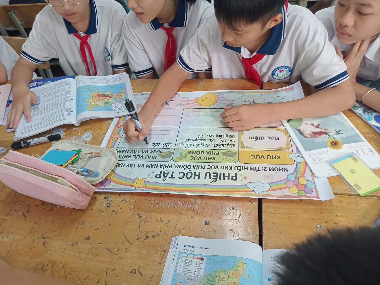 A group of children writing on a paper

Description automatically generated